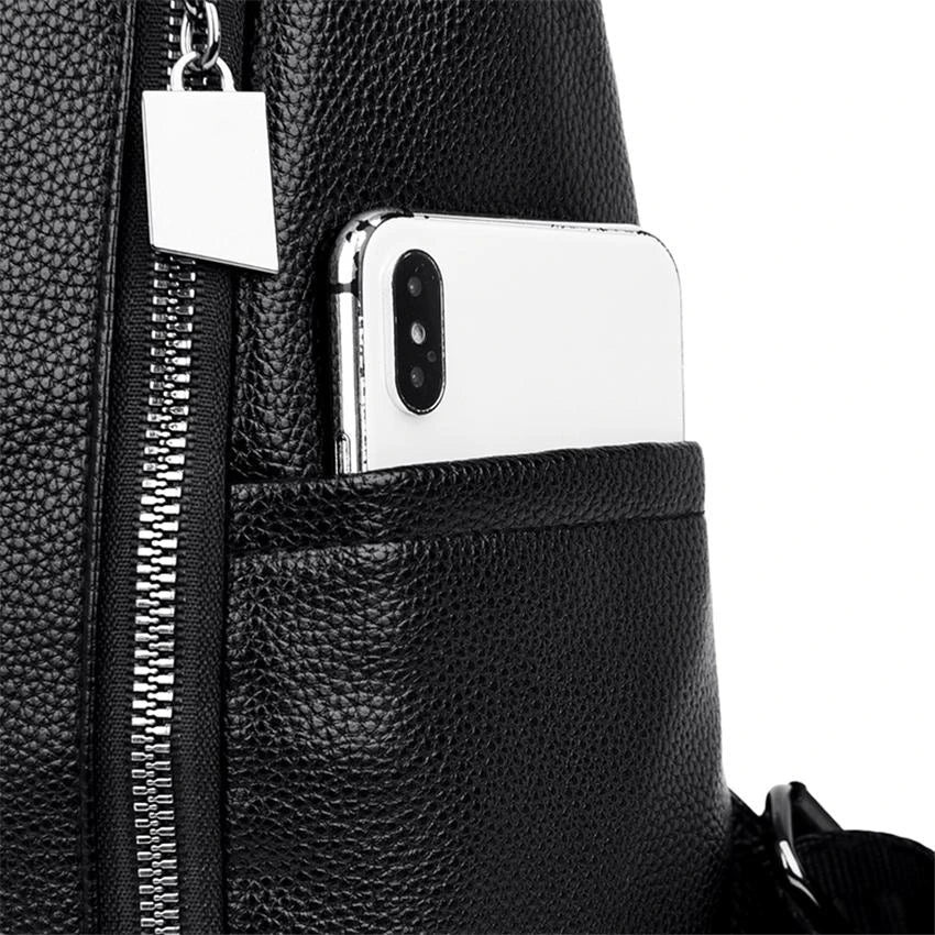 A stylish women's backpack with a sleek design, featuring a sturdy handle, adjustable shoulder straps, and side hooks for versatile carrying options. The bag has a smooth finish and a spacious main compartment, ideal for everyday use or travel.